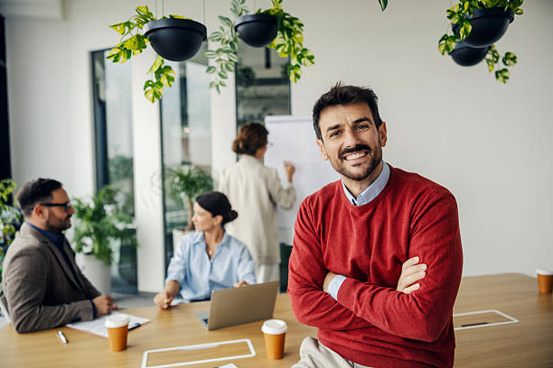 istock Confident businessman smiling during team meeting in modern office 2242952072