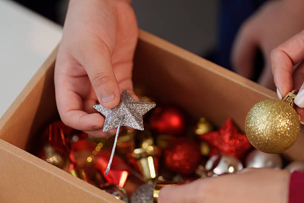 istock SSTK Christmas. Hands selecting festive ornaments from a box for holiday decorating. 2242958786
