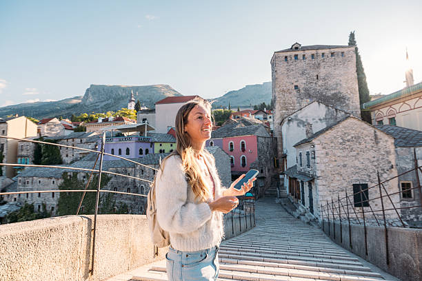 istock Woman Using Phone on Historic Stone Bridge 2242959718