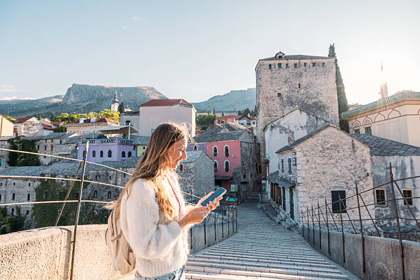 istock Woman Using Phone on Historic Stone Bridge 2242959733