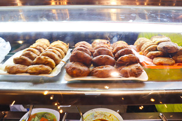 istock Assortment of freshly baked pastries and donuts displayed in a bakery case 2242970703