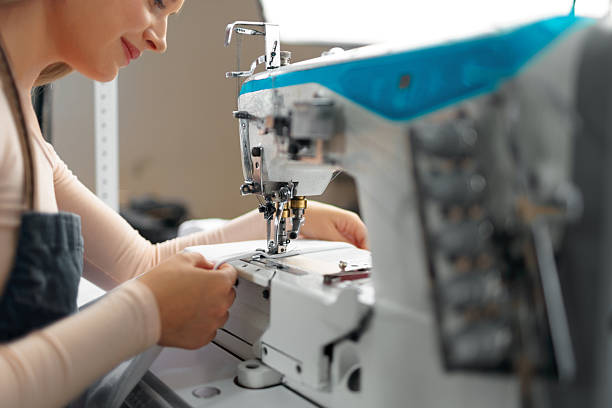 istock Seamstress woman at her workplace sewing clothes on sewing machine 2242971253