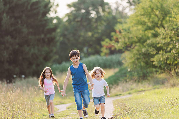istock Children Racing Along a Dirt Path in the Wild 2242972737