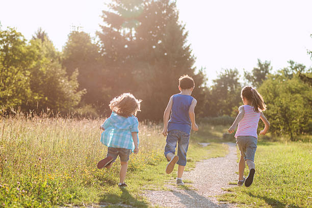 istock Joyful Kids Running Outdoors at Golden Hour 2242973646