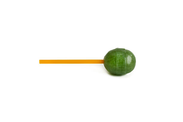 A green spherical lollipop is depicted on a white isolated background.