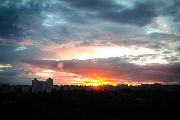 istock A breathtaking panoramic view of a dramatic sunset sky with fiery orange dark clouds. A dark city skyline is silhouetted against sunset. Clouds and the setting sun create a mesmerizing atmosphere 2242975566