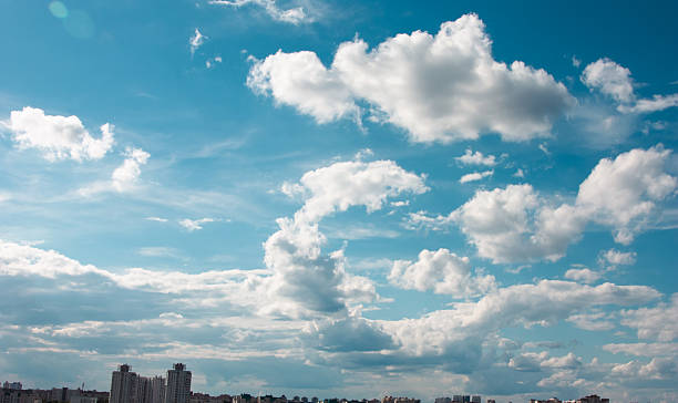 istock Blue sky background with clouds. High clear bright blue sky over the city with fluffy clouds on a sunny day 2242976656