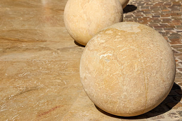 Stylish massive stone spheres gracefully arranged on a beautifully paved urban square, creating a striking modern cityscape.