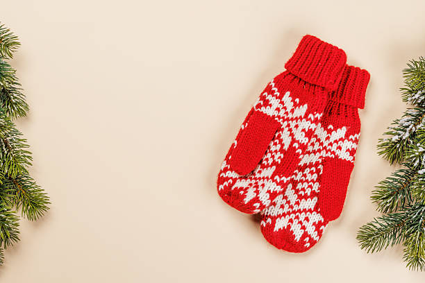 istock Christmas card with fir branches and mittens on beige surface 2242985470