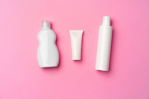 istock Three white cosmetic bottles on pink background flat lay 2242985631