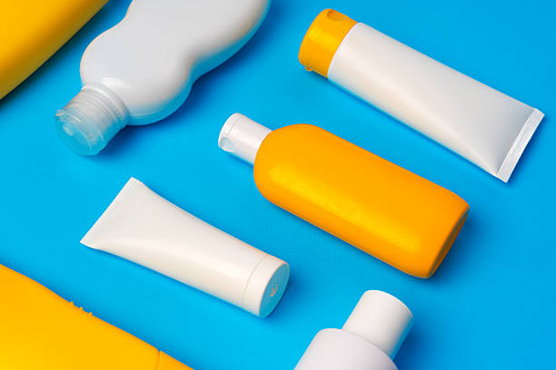 istock Bottles of sunscreen cream on blue background 2242988483