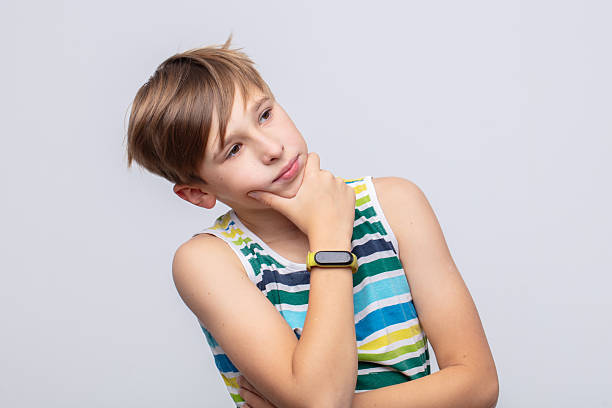istock Boy in striped tank top thinking thoughtfully in a neutral background during daytime 2242990554