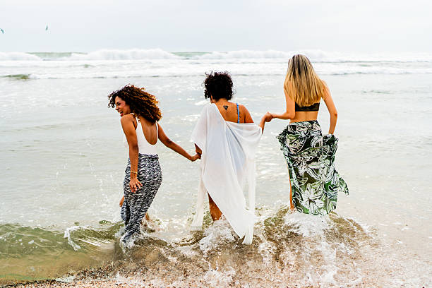 Young friends women having fun on the beach