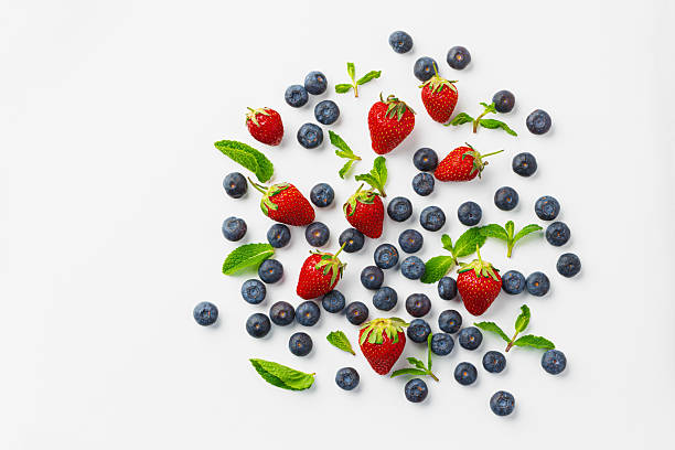 istock Strawberries and blueberries scattered on white background 2242996008