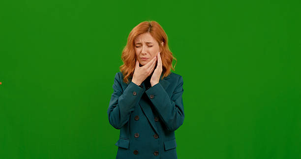 istock Woman suffering from toothache footage on green background. 2242997821