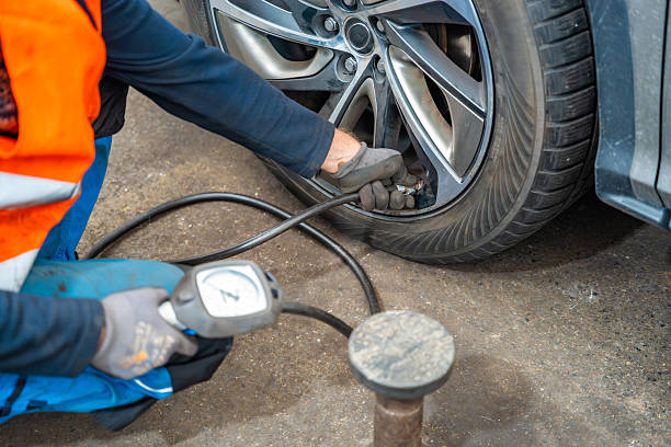 istock Worker checking tire pressure with gauge after seasonal wheel replacement. Final step of winter tire preparation in auto service in Czech Republic. 2242997907