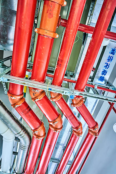 The pipes are white and red on ceiling of building. building pipe systems.