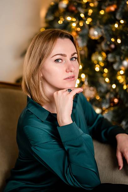 istock Woman Posing Thoughtfully Near Christmas Tree 2242998378