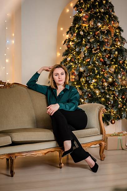 istock Woman Relaxing on Sofa by Christmas Tree at Home 2242998774