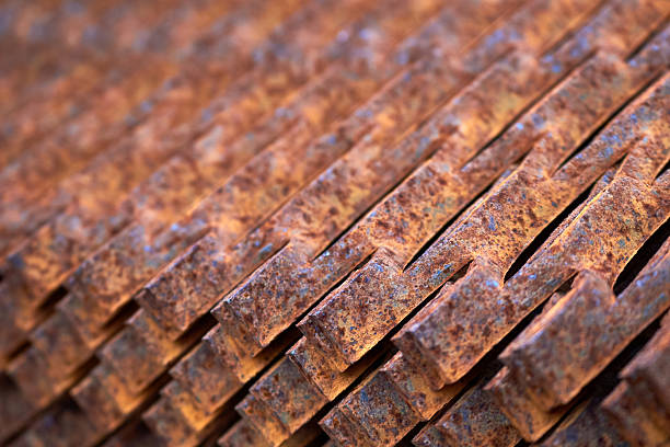 Perforated rusty metal floor sheet stamping plates texture closeup angled view. Metal stamping sheet metal manufacturing lightweight bearing flooring elements structural combine strength functionality