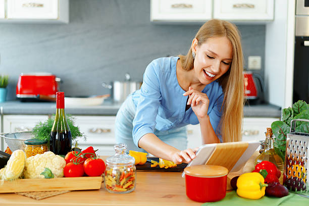istock Young beautiful caucasian woman cooking and using her digital tablet in kitchen 2243001778