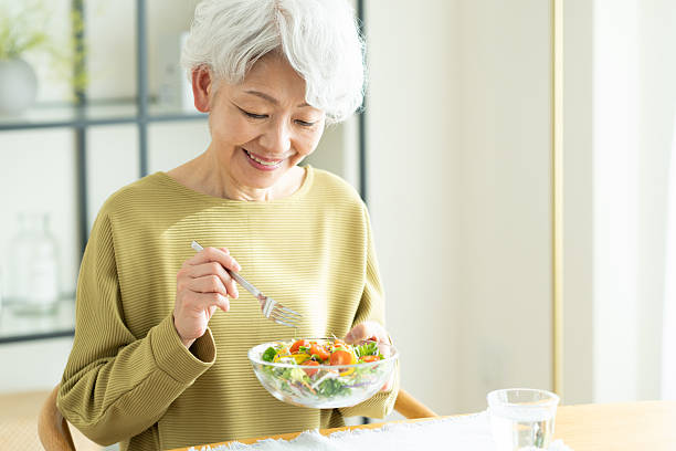 istock Senior woman eating salad 2243002283