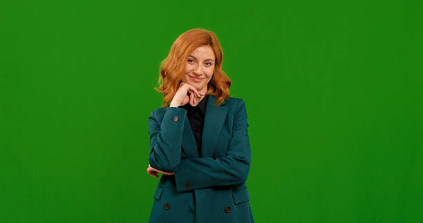 istock Smiling woman is posing on green screen background. 2243002570