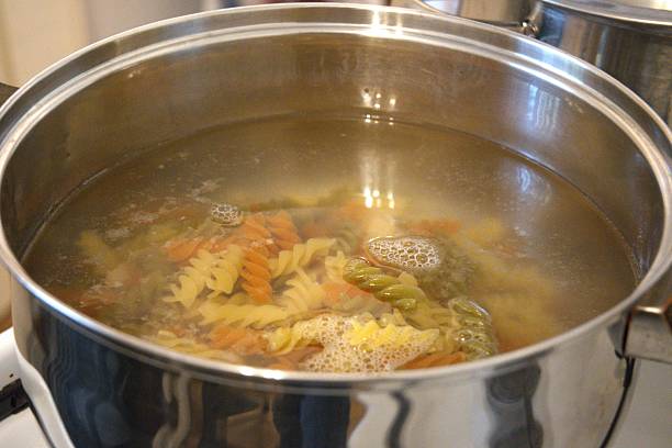 istock Multi colored fusilli pasta boiling in cooking pan, close-up 2243003862