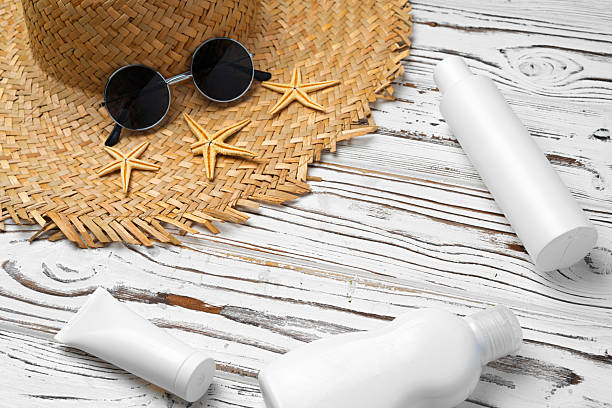 istock Straw hat, sunglasses and sunscreen bottle on wooden background 2243005454