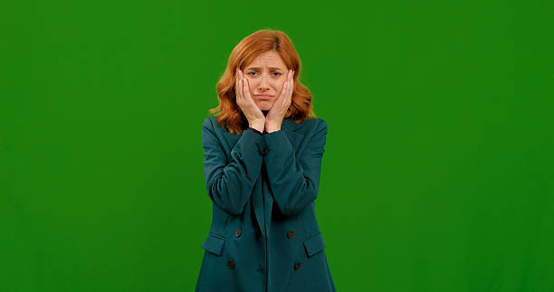 istock Woman shows various emotions with gestures against a green backdrop 2243006579