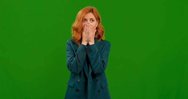 istock Woman expresses various gestures indoors with a green background 2243007059