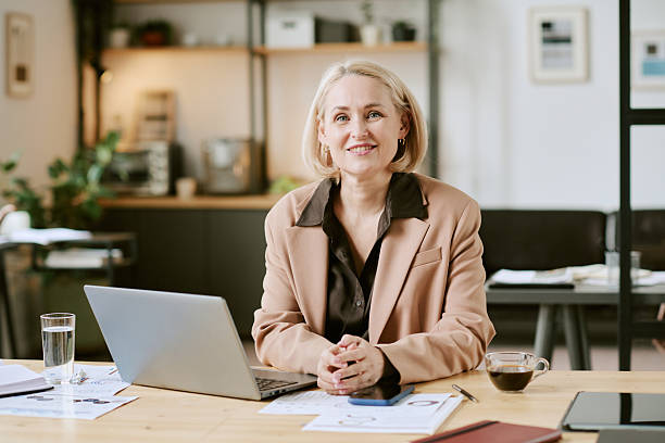 istock Portrait of Middle Aged Woman Smiling While Working at Desk 2243010628