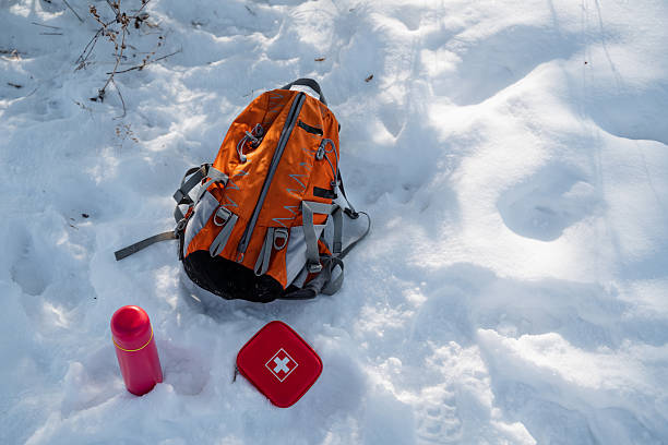 istock A bright orange backpack is resting in the softly falling snow next to a vibrant red first aid kit, which creates an eyecatching contrast against the stunningly beautiful wintry landscape 2243010936