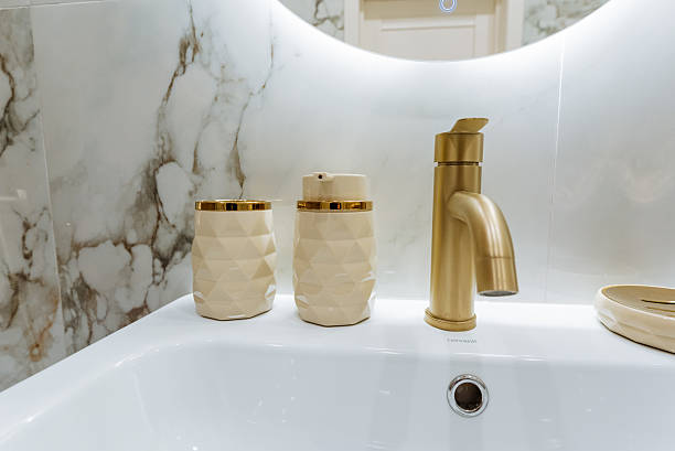istock A bathroom sink with a gold faucet and a mirror 2243010992