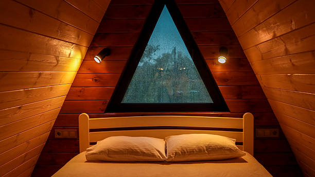 istock Cozy bedroom interior with a triangular window and wooden walls 2243011093