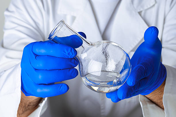 istock Scientist hands holding some liquid in a glassware in laboratory for analysis 2243012528