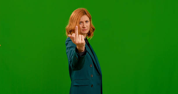 istock Rude woman shows fuck you in studio while feeling angry. 2243013939