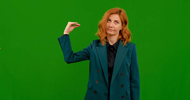 istock Woman showcases various gestures in a creative setting with green background 2243015385