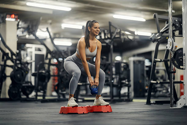 istock Woman exercising with kettlebell doing squats in gym 2243015488