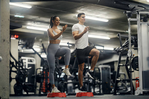 istock Couple doing high knee step aerobics in gym 2243015926