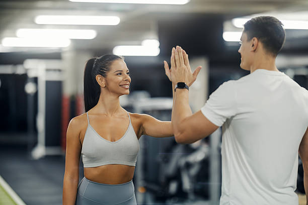 istock Personal trainer and woman celebrating gym workout success 2243015991