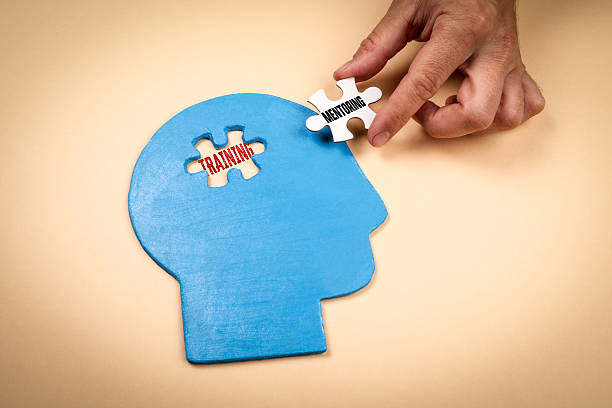 istock Concept of training and mentoring represented by puzzle pieces fitting into a blue human head shape on beige background symbolizing learning and personal development 2243016807