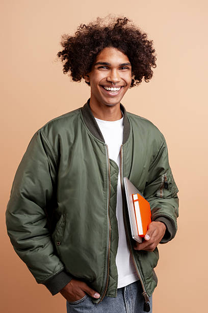 istock Happy student standing, smiling, holding books 2243016999