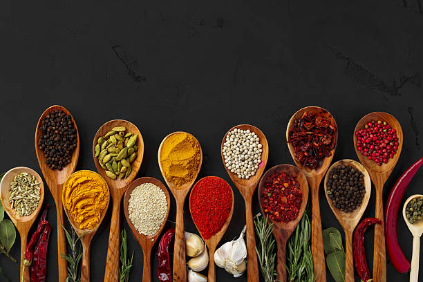istock Various exotic spices in wooden spoons on dark background 2243017461