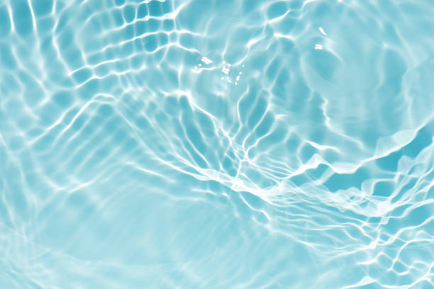 istock Blue water with ripples on the surface. Defocus blurred transparent blue colored clear calm water surface texture with splashes and bubbles. Water waves with shining pattern texture background. 2243017589