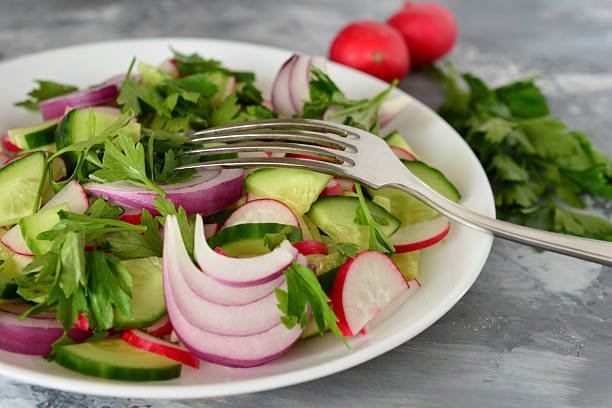 Healthy Spring Salad with Radishes and Cucumbers and a fork close up