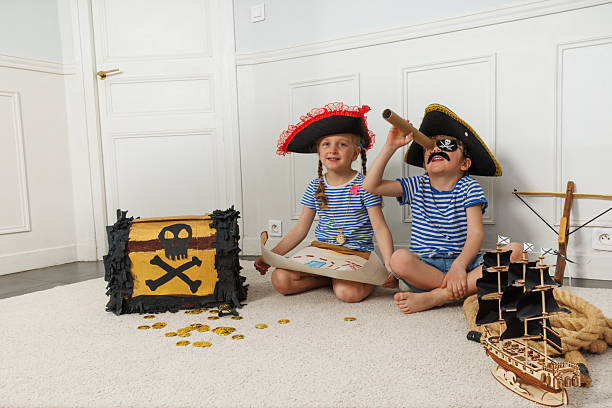 istock Excited kids, dressed as pirates, play with treasure and ships 2243024573