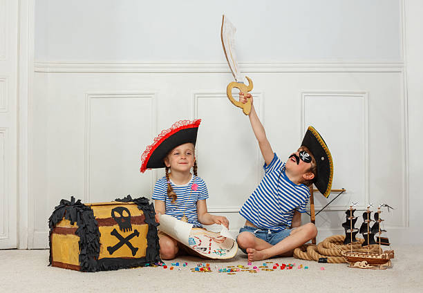 istock Pirate-themed party: kids with map, hat, and a treasure chest 2243024588