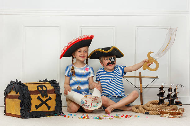 istock Two kids explore pirate adventures with map, sword and chest 2243024591