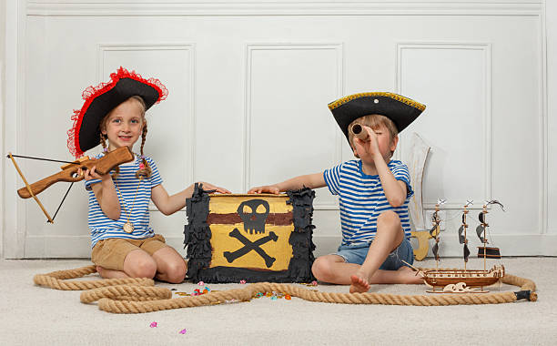 istock Young pirates with a treasure chest and telescope in playtime 2243024593